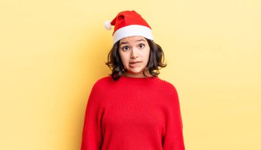 Genç İspanyol kadın şaşkın ve şaşkın görünüyor. Noel konsepti