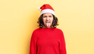 Genç İspanyol kadın iğreniyor, sinirleniyor ve dili dışarı çıkıyor. Noel konsepti