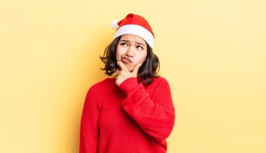 Genç İspanyol kadın düşünüyor, kuşkulu ve şaşkın hissediyor. Noel konsepti