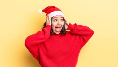 Genç İspanyol kadın mutlu, heyecanlı ve şaşırmış hissediyor. Noel konsepti