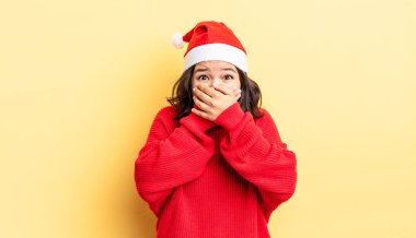 Genç İspanyol kadın şok olmuş ellerle ağzını kapatıyor. Noel konsepti