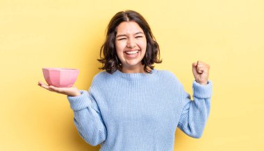 Genç İspanyol kadın şokta, gülüyor ve başarıyı kutluyor. boş kase kavramı