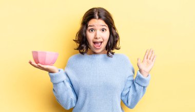 Genç İspanyol kadın kendini mutlu hissediyor ve inanılmaz bir şeye hayret ediyor. boş kase kavramı