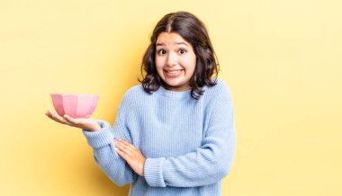 Genç İspanyol kadın omuz silkiyor, kafası karışık ve kararsız. boş kase kavramı