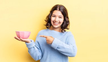 Genç İspanyol kadın heyecanlı ve şaşırmış görünüyor. boş kase kavramı