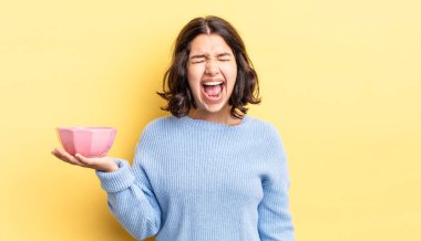 Genç İspanyol kadın agresif bir şekilde bağırıyor, çok kızgın görünüyor. boş kase kavramı