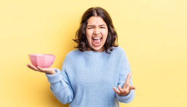 Genç İspanyol kadın kızgın, sinirli ve hayal kırıklığına uğramış görünüyor. boş kase kavramı