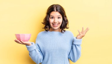 Genç İspanyol kadın kendini mutlu hissediyor, bir çözüm ya da fikir bulduğuna şaşırıyor. boş kase kavramı