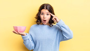 Genç İspanyol kadın şaşırmış görünüyor, yeni bir düşünce, fikir ya da konsept keşfediyor. boş kase kavramı