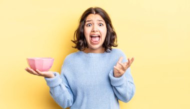 Genç İspanyol kadın umutsuz, hayal kırıklığına uğramış ve stresli görünüyor. boş kase kavramı