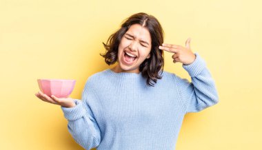 Genç İspanyol kadın mutsuz ve stresli görünüyor, intihar jesti silah işareti yapıyor. boş kase kavramı