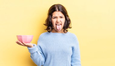 Genç İspanyol kadın iğreniyor, sinirleniyor ve dili dışarı çıkıyor. boş kase kavramı