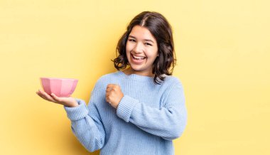 Genç İspanyol kadın kendini mutlu hissediyor ve bir meydan okumayla yüzleşiyor ya da kutluyor. boş kase kavramı