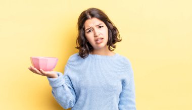 Genç İspanyol kadın şaşkın ve şaşkın hissediyor. boş kase kavramı