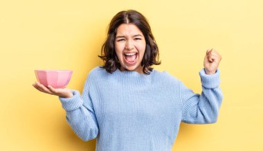 Genç İspanyol kadın öfkeli bir ifadeyle agresif bir şekilde bağırıyor. boş kase kavramı