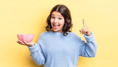 Genç İspanyol kadın bir fikri fark ettikten sonra mutlu ve heyecanlı bir dahi gibi hissediyor. boş kase kavramı