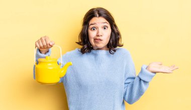 Genç İspanyol kadın şaşkın, şaşkın ve şüpheci hissediyor. çaydanlık konsepti