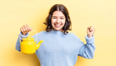 Genç İspanyol kadın şokta, gülüyor ve başarıyı kutluyor. çaydanlık konsepti