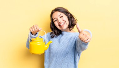 Genç İspanyol kadın gururlu, olumlu bir şekilde gülümsüyor. çaydanlık konsepti