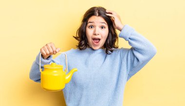 Genç İspanyol kadın mutlu, şaşkın ve şaşırmış görünüyor. çaydanlık konsepti