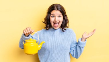 Genç İspanyol kadın kendini mutlu hissediyor ve inanılmaz bir şeye hayret ediyor. çaydanlık konsepti