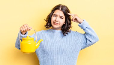 Genç İspanyol kadın şaşkın ve şaşkın hissediyor, senin deli olduğunu gösteriyor. çaydanlık konsepti