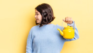 Profil görünümlü genç İspanyol kadın hayal mi kuruyor yoksa hayal mi kuruyor? çaydanlık konsepti