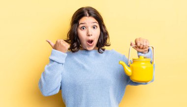 İnançsızlığa şaşırmış genç İspanyol kadın. çaydanlık konsepti