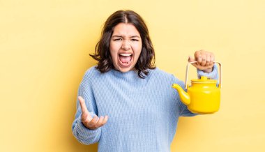 Genç İspanyol kadın kızgın, sinirli ve hayal kırıklığına uğramış görünüyor. çaydanlık konsepti