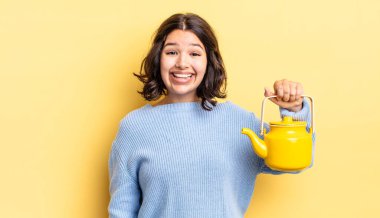 Genç İspanyol kadın mutlu ve hoş bir şekilde şaşırmış görünüyor. çaydanlık konsepti