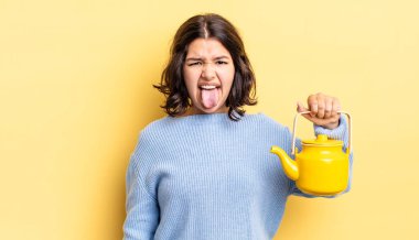 Genç İspanyol kadın iğreniyor, sinirleniyor ve dili dışarı çıkıyor. çaydanlık konsepti