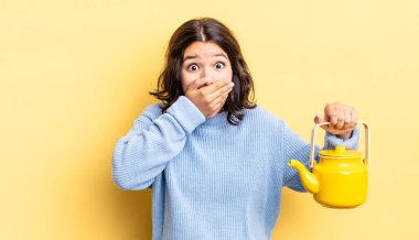 Genç İspanyol kadın şok olmuş ellerle ağzını kapatıyor. çaydanlık konsepti