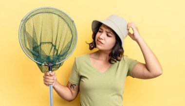 Genç İspanyol kadın mutlu bir şekilde gülümsüyor ve hayal kuruyor ya da şüphe ediyor. balıkçı ağı kavramı