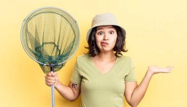 Genç İspanyol kadın şaşkın, şaşkın ve şüpheci hissediyor. balıkçı ağı kavramı