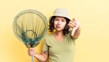 Latin kökenli genç bir kadın kızmış, baş parmağını kaldırmış. balıkçı ağı kavramı