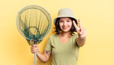 Genç İspanyol kadın gülümsüyor ve arkadaş canlısı görünüyor, iki numarayı gösteriyor. balıkçı ağı kavramı