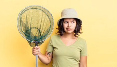 Genç İspanyol kadın üzgün, üzgün ya da kızgın hissediyor ve yana bakıyor. balıkçı ağı kavramı