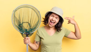 Genç İspanyol kadın mutsuz ve stresli görünüyor, intihar jesti silah işareti yapıyor. balıkçı ağı kavramı