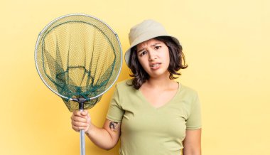 Genç İspanyol kadın şaşkın ve şaşkın hissediyor. balıkçı ağı kavramı