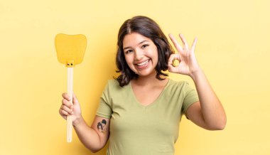 Genç İspanyol kadın kendini mutlu hissediyor, iyi bir jestle onaylıyor. Öldürme konsepti