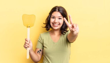 Genç İspanyol kadın gülümsüyor ve mutlu görünüyor, zafer ya da barış işareti yapıyor. Öldürme konsepti