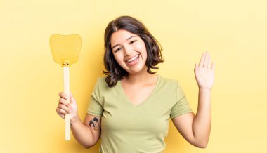 Genç İspanyol kadın mutlu bir şekilde gülümsüyor, el sallıyor, sizi selamlıyor ve selamlıyor. Öldürme konsepti