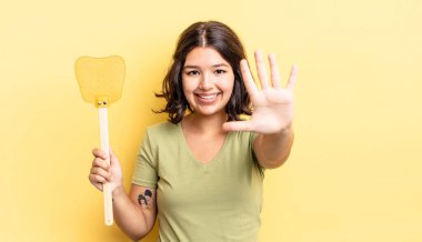 Genç İspanyol kadın gülümsüyor ve arkadaş canlısı görünüyor, beş numarayı gösteriyor. Öldürme konsepti