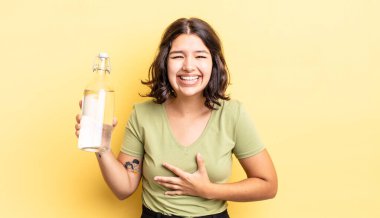 Genç İspanyol kadın komik bir şakaya yüksek sesle gülüyor. su şişesi kavramı