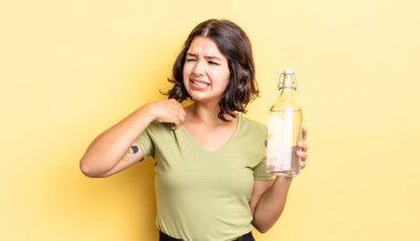 Genç İspanyol kadın stresli, endişeli, yorgun ve hayal kırıklığına uğramış hissediyor. su şişesi kavramı