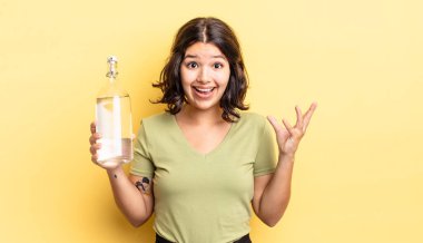 Genç İspanyol kadın kendini mutlu hissediyor, bir çözüm ya da fikir bulduğuna şaşırıyor. su şişesi kavramı