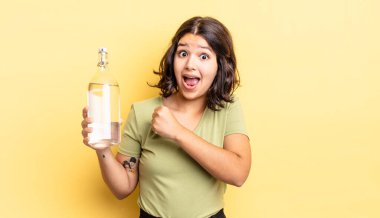 Genç İspanyol kadın kendini mutlu hissediyor ve bir meydan okumayla yüzleşiyor ya da kutluyor. su şişesi kavramı