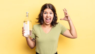 Genç İspanyol kadın ellerini havaya kaldırarak çığlık atıyor. su şişesi kavramı