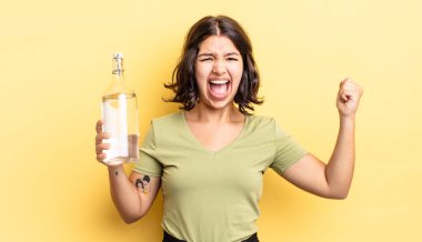 Genç İspanyol kadın öfkeli bir ifadeyle agresif bir şekilde bağırıyor. su şişesi kavramı