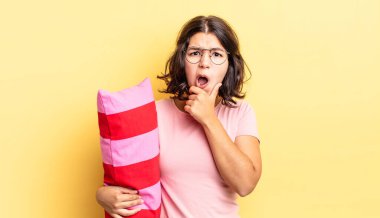 Ağzı ve gözleri sonuna kadar açık ve eli çenesinde olan genç İspanyol kadın. Sabah Uyanışı konsepti